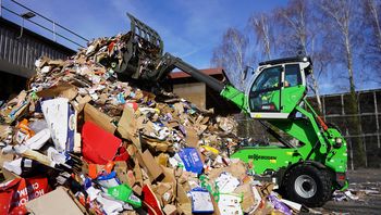 SENNEBOGEN 360 G Teleskoplader lagert Recyclingmaterial auf einem Materiallager im Recyclinghof.